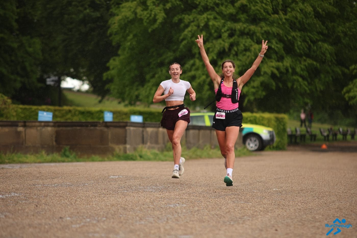 A runner celebrating with arms in the air at Heaton Park