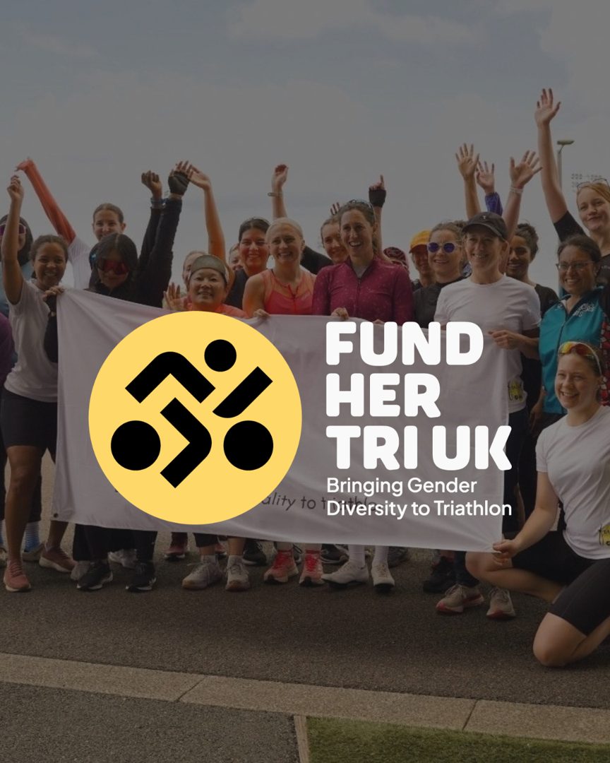 The Fund Her Tri UK community holding their banner at a Women's Run Series race