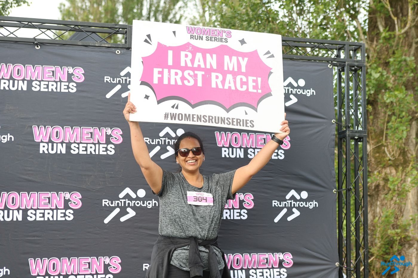 Runners with a #RunLikeAGirl sign at the Women's Run Series backdrop